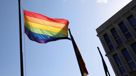 Eine Regenbogenflagge weht vor einem Gebäude.