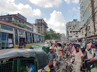 Autos, Busse, Mopeds, Motorräder, Fahrräder, Rikschas und Handkarren teilen sich in Dhaka die Straße.