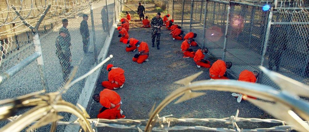 Ein von der US-Armee herausgegebenes Foto zeigt in orangefarbene Overalls gekleidete Häftlinge, die im Camp X-Ray auf dem US-Marinestützpunkt Guantánamo Bay auf Kuba auf dem Boden knien (Symbolbild).
