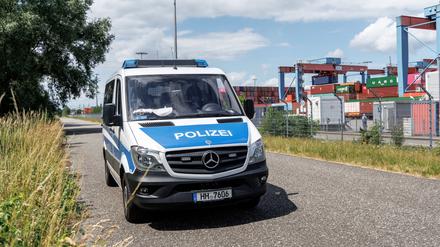 Ein Polizeifahrzeug park am Außenzaun des Containerterminals Hamburg-Altenwerder. 