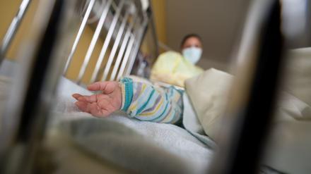 Ein Baby liegt auf einer Kinderstation im Krankenbett. 