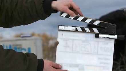 Ein Film-Team-Mitarbeiter hält eine Filmklappe. (Symbolbild)