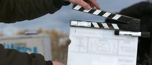 Ein Film-Team-Mitarbeiter hält eine Filmklappe. (Symbolbild)