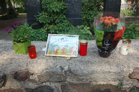 Kerzen, Blumen und eine gerahmte Gedenktafel - Freunde haben geschrieben "Wir werden Dich vermissen"