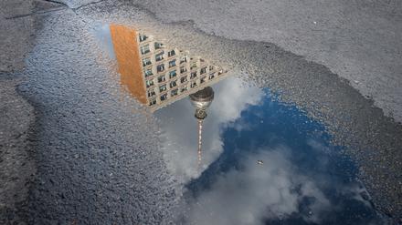 Der Berliner Fernsehturm spiegelt sich in einer Pfütze.