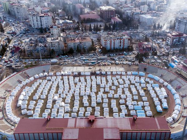 Ein Luftbild zeigt eine Zeltstadt in Maraş, einer Provinz in der Türkei. In den betroffenen Gebieten müssen die obdachlos gewordenen Menschen in Hilfsbehausungen leben.