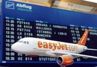 Ein Flugzeugmodell der britischen Billig-Airline easyJet steht vor der Anzeigetafel.
