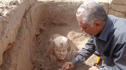 Ein Archäologe zeigt die ausgegrabene Kalkstein-Sphinx. 