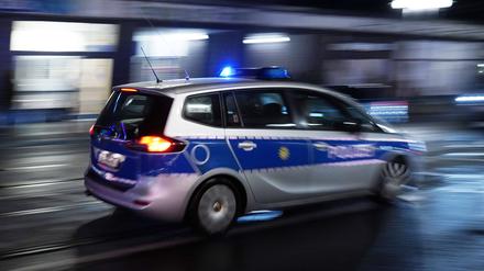 Ein Polizeiauto bei einer Einsatzfahrt mit Blaulicht, Symbolbild.