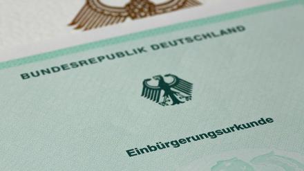 Eine Einbürgerungsurkunde der Bundesrepublik Deutschland liegt auf einem Tisch. 