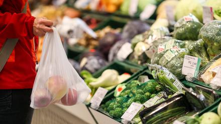 Eine Kundin steht mit einem Mehrweg-Einkaufsnetz in der Obst- und Gemüseabteilung in einem Supermarkt. Angesichts der Preisexplosion in Supermärkten und bei Discountern befürwortet die breite Mehrheit der Menschen in Deutschland einer Umfrage zufolge nun auch staatliche Eingriffe bei den Lebensmittelpreisen. 