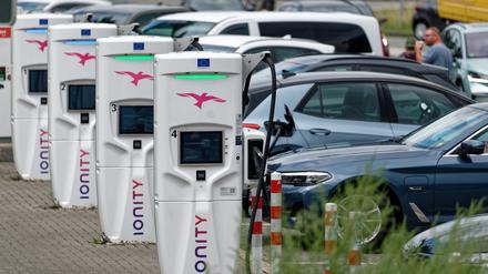 Elektroautos laden an eine Ladestation an einer Autobahnraststätte.