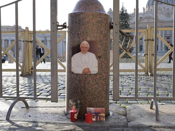 Ein Foto des emeritierten Papstes Benedikt XVI. und Kerzen sind am Petersplatz zu sehen.