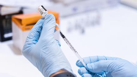 Ein Mitarbeiter eines mobilen Impfteams zieht eine Spritze mit dem Impfstoff von BioNTech/Pfizer gegen das Coronavirus.