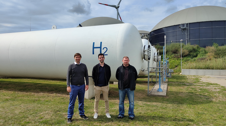 Enertrags Projektleiter Peter Agoston, Referent Matthias Philippi und den Anlagenleiter Nico Vollack (von links) vor dem Hybridkraftwerk Prenzlau.