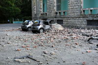 Nach dem Erdbeben stehen zwei Männer neben einem beschädigten Gebäude.