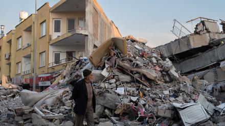 Ein Mann geht durch die Trümmer von Gebäuden, die durch das Erdbeben eingestürzt sind. 