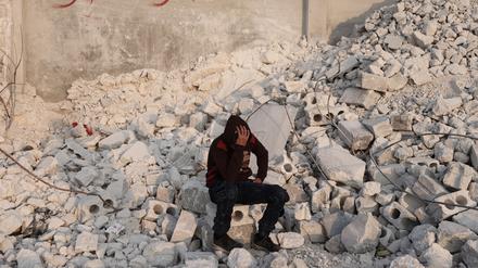 Der 15-jährige Muhammad Al-Mula sitzt in der Nähe seines zerstörten Hauses, das durch das Erdbeben an der türkisch-syrischen Grenze zerstört wurde. 