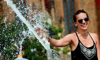 Eine junge Frau erfrischt sich bei Temperaturen um 37 Grad Celsius an den Wasserspielen des Neptunbrunnens in Berlin. Das war am 11. August.