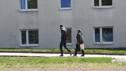Asylbewerber gehen auf dem Gelände der Erstaufnahmeeinrichtung des Landes Thüringen in Suhl spazieren.