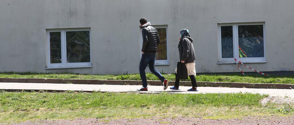 Asylbewerber gehen auf dem Gelände der Erstaufnahmeeinrichtung des Landes Thüringen in Suhl spazieren.