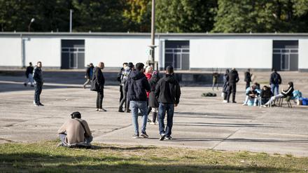 Asylsuchende laufen in der Erstaufnahmeeinrichtung Eisenhüttenstadt über einen Platz. 