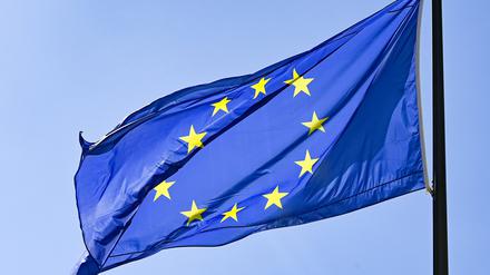 Eine Europaflagge weht vor blauem Himmel.
