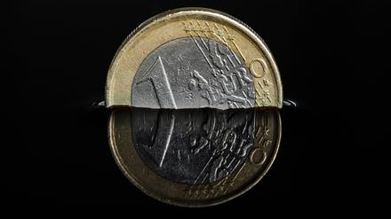 Euro-Münze in einer dunklen Flüssigkeit.