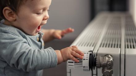 Excited baby boy playing with thermostat of heater model released Symbolfoto property released PUBLICATIONxINxGERxSUIxAUTxHUNxONLY SEBF00020  