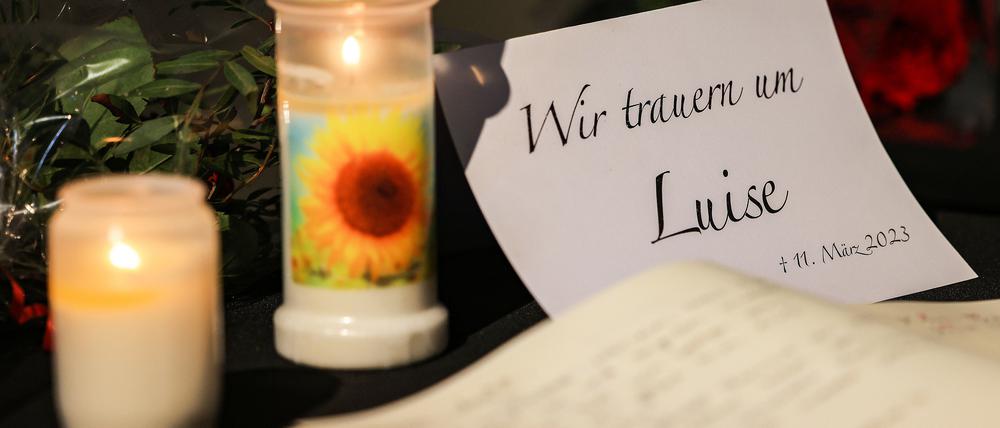 Ein Kondolenzbuch für die getötete Luise liegt neben Blumen und Kerzen in einer Kirche in Freudenberg aus. 