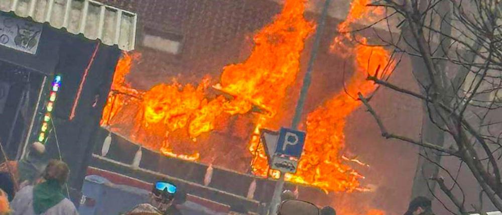 Ein Faschingswagen steht brennend auf einer Straße. 