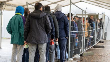 In der Landeserstaufnahmestelle warten Flüchtlinge in einer Schlange vor der Essensausgabe. 