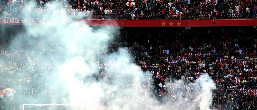This photograph taken on September 24, 2023, shows smoke rising from fireworks thrown on the field by Ajax' supporters during the Dutch Eredivisie football match between Ajax Amsterdam and Feyenoord at the Johan Cruijff Arena in Amsterdam. (Photo by Olaf Kraak / ANP / AFP) / Netherlands OUT