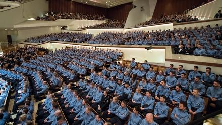 Junge Polizeibeamte sitzen 2017 bei der feierlichen Vereidigung der Berufsanfänger des mittleren und gehobenen Dienstes bei der Berliner Polizei in Berlin.
