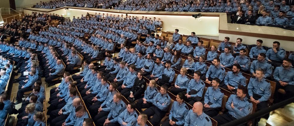 Junge Polizeibeamte sitzen 2017 bei der feierlichen Vereidigung der Berufsanfänger des mittleren und gehobenen Dienstes bei der Berliner Polizei in Berlin.