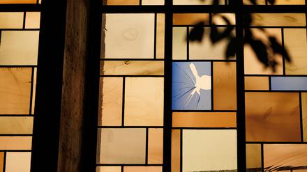 Ein beschädigtes Bleiglasfenster ist von der Außenseite der Synagoge aus zu sehen. A