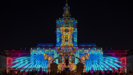 Zahlreiche Menschen schauen sich beim Festival of Lights die Illumination auf der Fassade vom Schloss Charlottenburg an. 