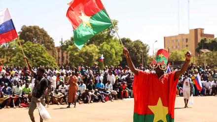 Ein Mann hält seine Nationalflagge in die Höhe, als sich Menschen auf dem Place de la Nation in Ouagadougou, Burkina Faso, am 20. Januar 2023 versammeln, um ihre Unterstützung für den Junta-Führer Ibrahim Traore zu zeigen und die Abreise des französischen Botschafters zu fordern.
