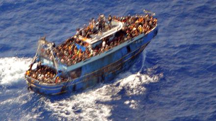 Ein undatiertes Handout-Foto der griechischen Küstenwache zeigt Migranten an Bord eines Bootes während einer Rettungsaktion, bevor ihr Boot auf dem offenen Meer vor Griechenland kentert.