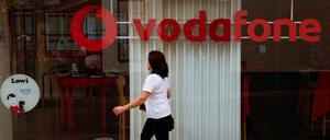 Eine Frau läuft an einem Geschäft von Vodafone vorbei.