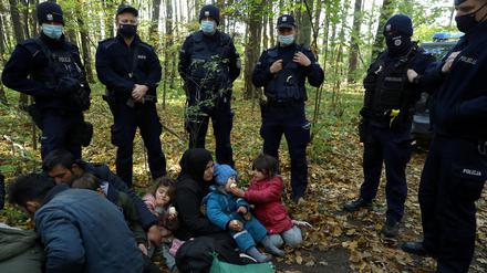 Polnische Grenzbeamte stehen um eine irakische Frau mit Kindern herum: 2021 eskalierte die Lage an der Grenze zu Belarus. 