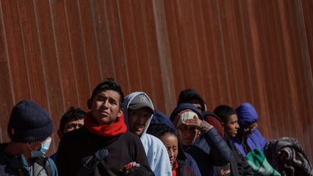 Migranten stehen an der Grenze zwischen Mexico und den USA.