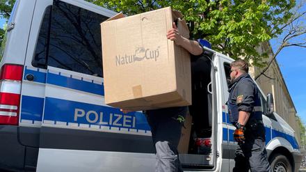 Ein Polizist trägt Kisten auf eine Polizeiwache.