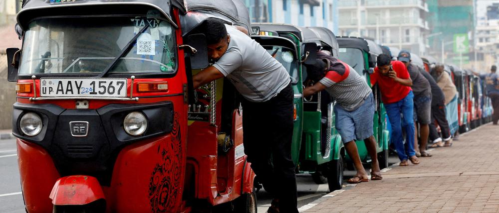 FILE PHOTO: FILE PHOTO: Drivers push auto rickshaws in a line to buy petrol from a fuel station amid Sri Lanka's economic crisis, in Colombo, Sri Lanka, July 29, 2022. REUTERS/Kim Kyung-Hoon/File Photo/File Photo