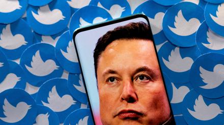 FILE PHOTO: An image of Elon Musk is seen on a smartphone placed on printed Twitter logos in this picture illustration taken April 28, 2022. REUTERS/Dado Ruvic/Illustration//File Photo