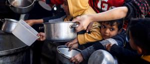 Kinder in Rafah warten auf Lebensmittel Lieferungen. 