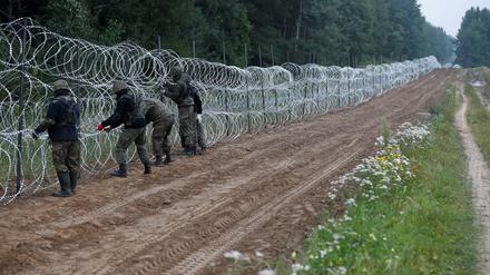 Polnische Soldaten bauen einen Zaun an der belarussischen Grenze.
