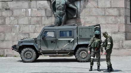 Russische Soldaten vor dem Russian servicemen patrol vor einem Monument in Cherson im Mai.