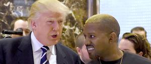 Auf diesem Dateifoto vom 13. Dezember 2016 kommen der Sänger Kanye West und der designierte US-Präsident Donald Trump nach ihrem Treffen im Trump Tower in New York zum Gespräch mit der Presse.