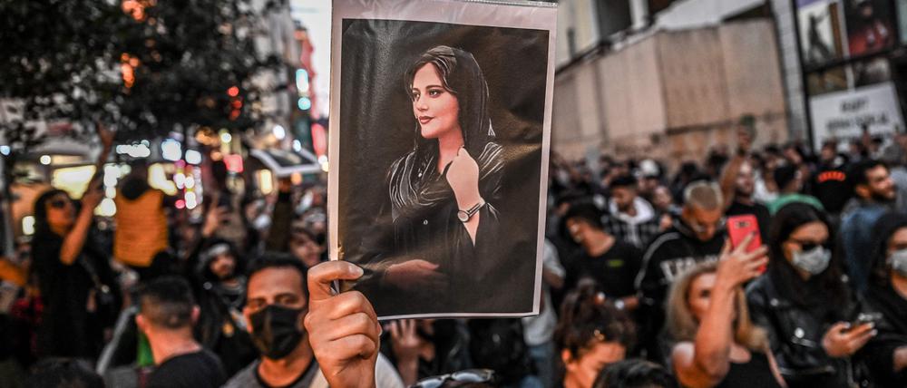 (FILES) In this file photo taken on September 20, 2022 a protester holds a portrait of Mahsa Amini  during a demonstration in support of Amini, a young Iranian woman who died after being arrested in Tehran by the Islamic Republic's morality police, on Istiklal avenue in Istanbul. - Amini, 22, was on a visit with her family to the Iranian capital when she was detained on September 13 by the police unit responsible for enforcing Iran's strict dress code for women, including the wearing of the headscarf in public. She was declared dead on September 16 by state television after having spent three days in a coma. (Photo by Ozan KOSE / AFP)